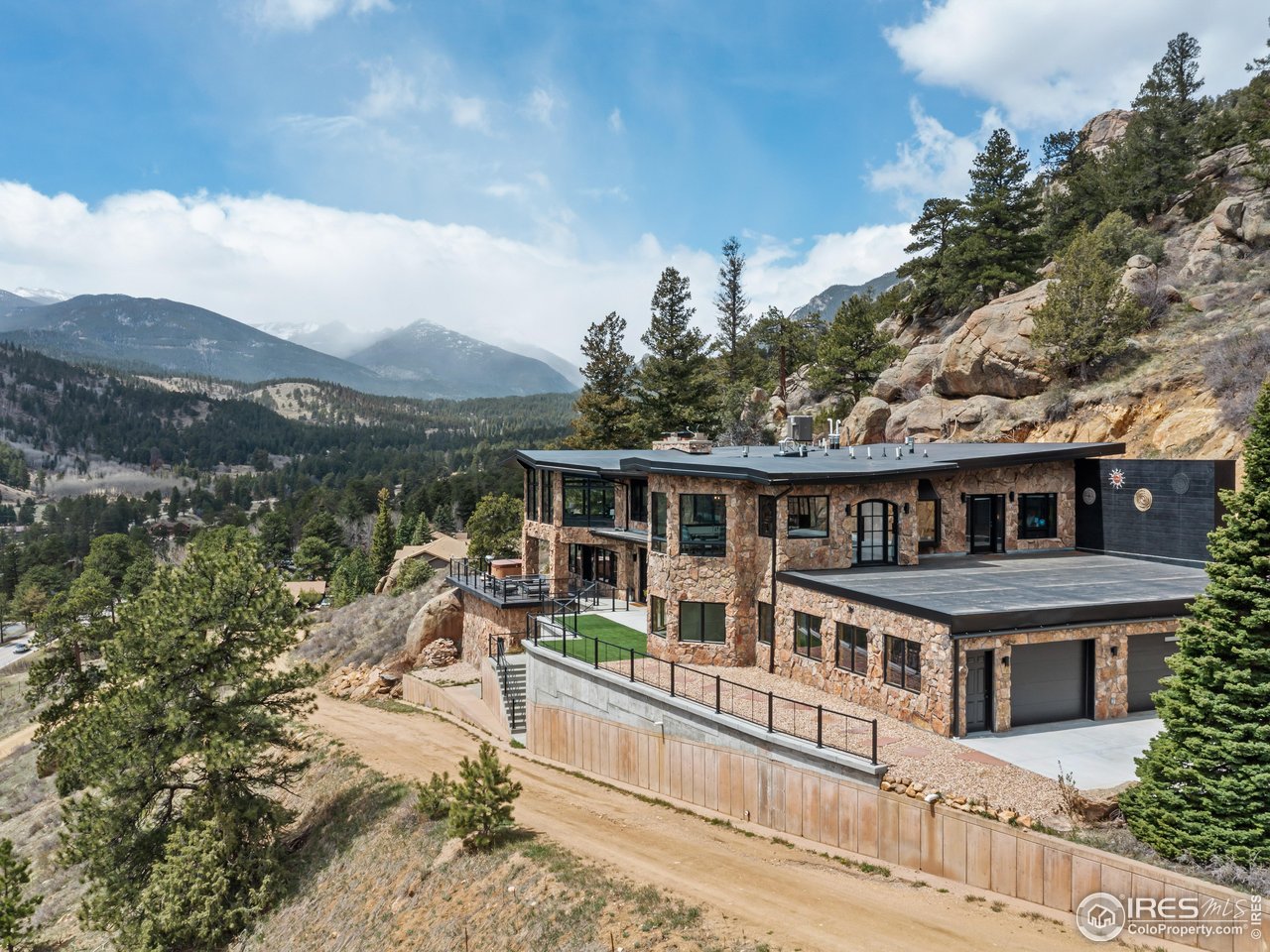 2701 Fall River Road Estes Park, CO 80517 - Photo 2 of 40 a view of a house with a wooden deck and a mountain view