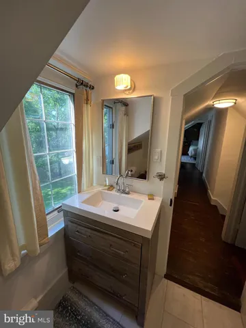 a bathroom with a sink a toilet a mirror and window