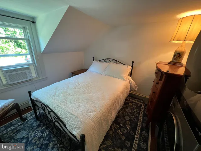 a bed sitting in a bedroom next to a window