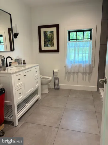 a spacious bathroom with a toilet sink and mirror