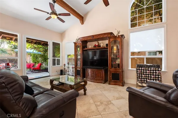 a living room with furniture a flat screen tv and floor to ceiling window
