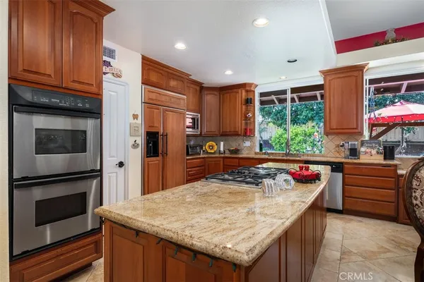 a kitchen with stainless steel appliances granite countertop a stove refrigerator and cabinets