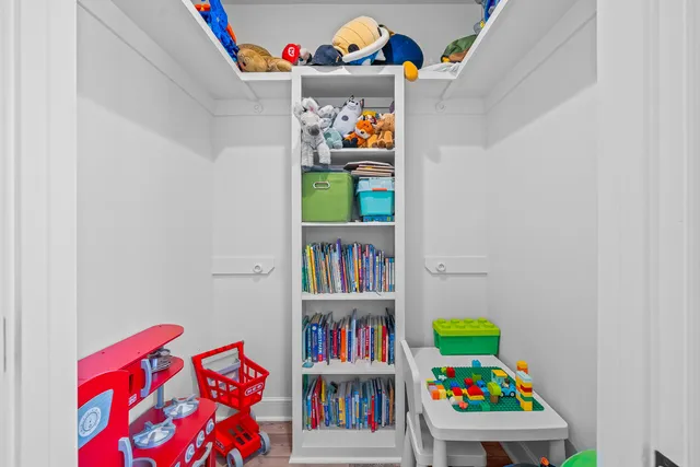 a living room with lots of baby toys and a book shelf