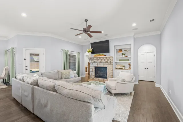 a living room with furniture a fireplace and a chandelier