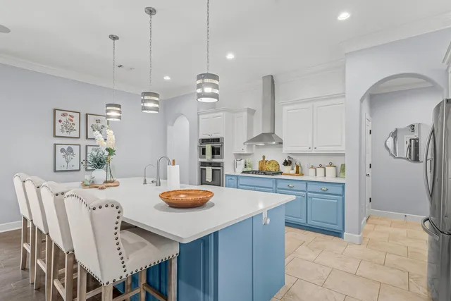 a kitchen with stainless steel appliances granite countertop a dining table chairs and white cabinets