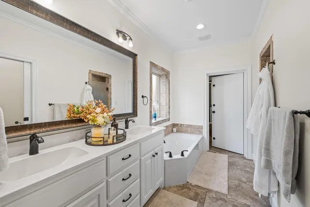 a spacious bathroom with double vanity sinks a mirror and a shower