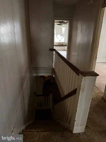 a view of staircase with railing and a window