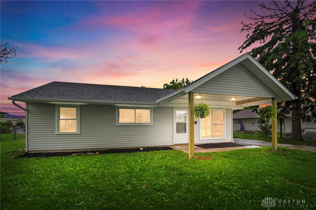 1923 Portage Path Springfield, OH 45506 - Photo 1 of 40 A well-maintained single-story residence with a covered porch and simple landscaping beneath a twilight sky.