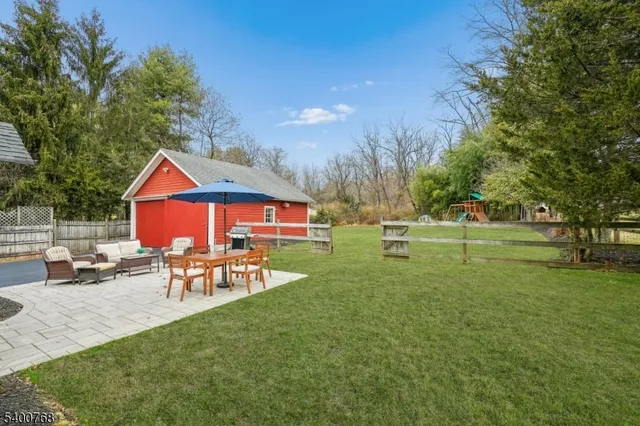 a view of a patio with couches table and chairs under an umbrella