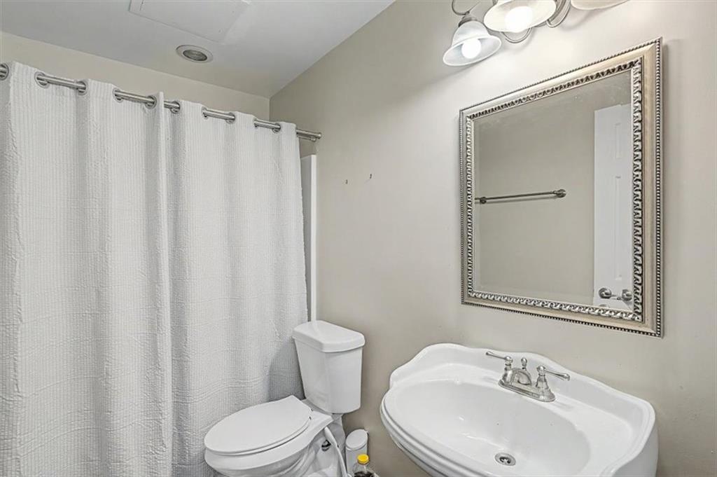 409 Windsor Way Canton, GA 30115 - Photo 23 of 51 a bathroom with a sink a toilet and shower curtain
