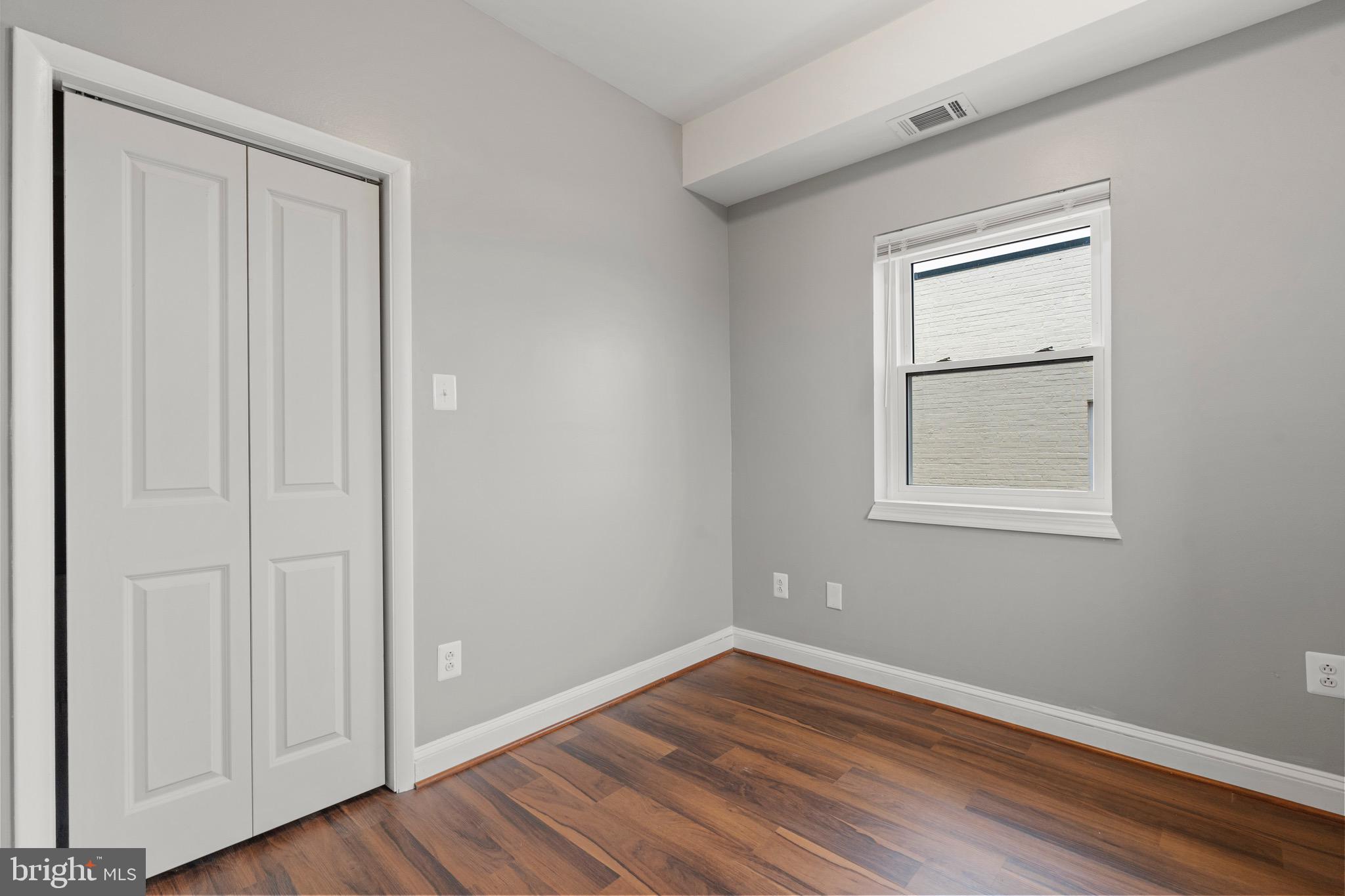 2834 R Street Southeast, Unit 5 Washington, DC 20020 - Photo 7 of 30 a view of an empty room with wooden floor and a window