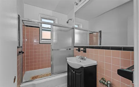 a bathroom with a sink a shower and a mirror