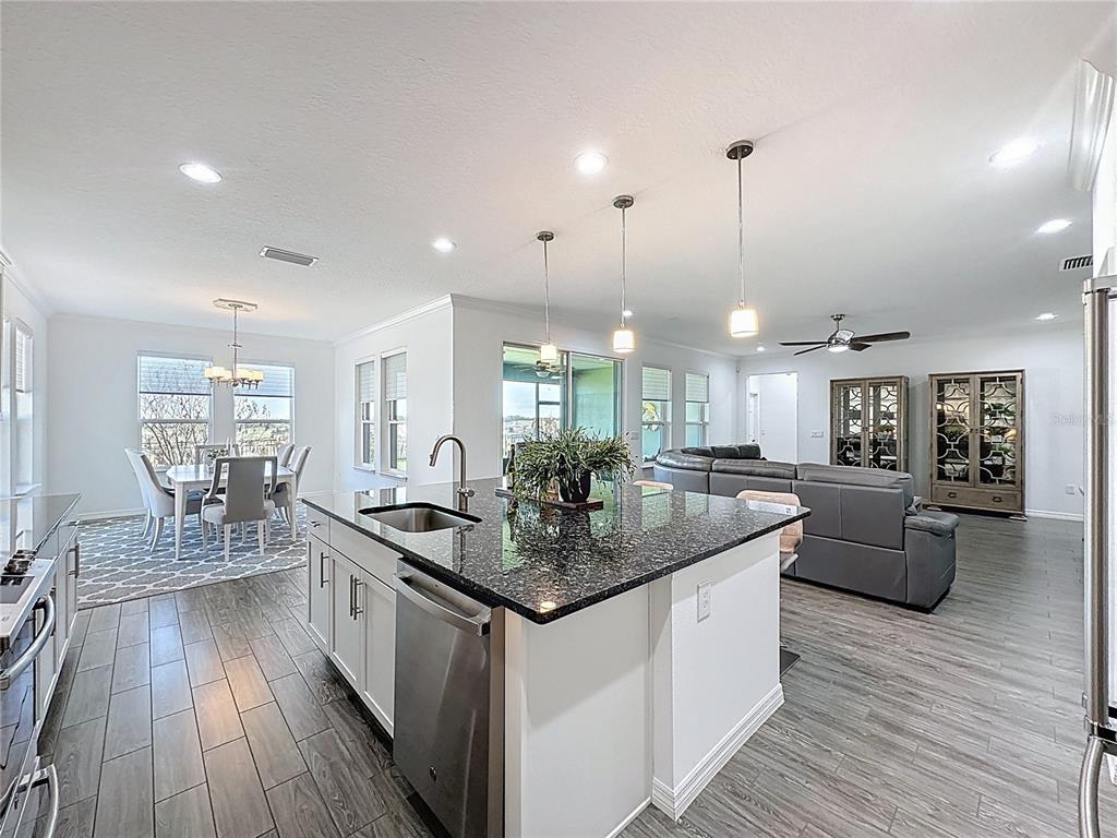178 Silver Maple Road Groveland, FL 34736 - Photo 13 of 72 a kitchen with stainless steel appliances granite countertop a sink stove and wooden floor