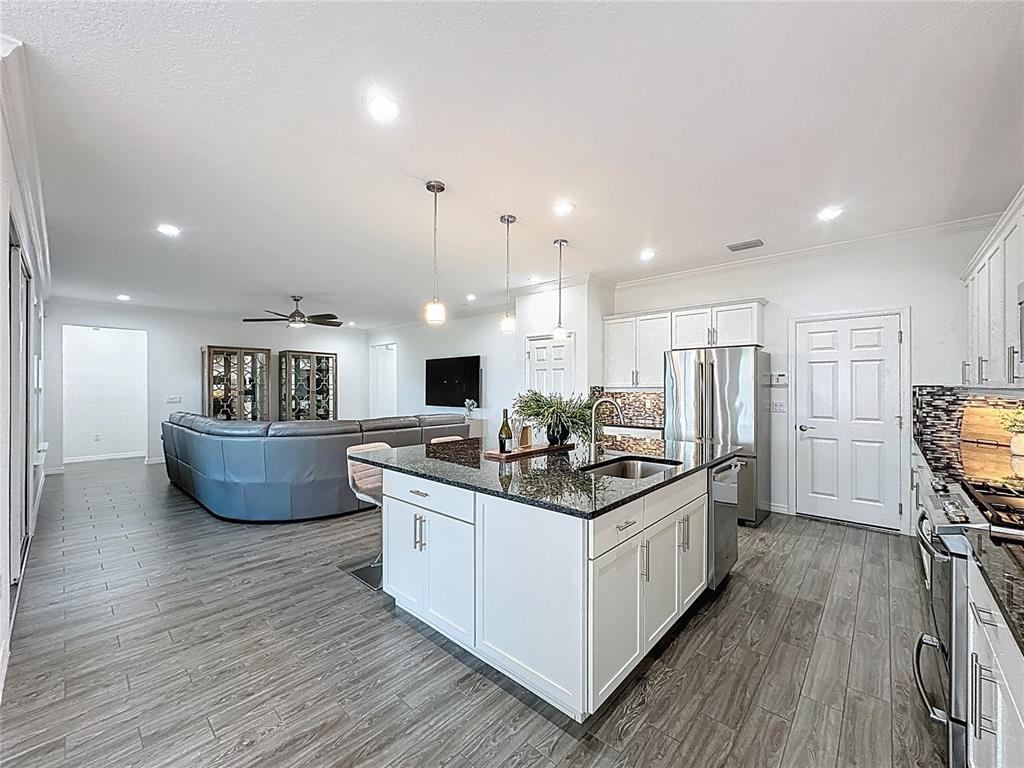 178 Silver Maple Road Groveland, FL 34736 - Photo 14 of 72 a kitchen with stainless steel appliances a sink stove and wooden floor