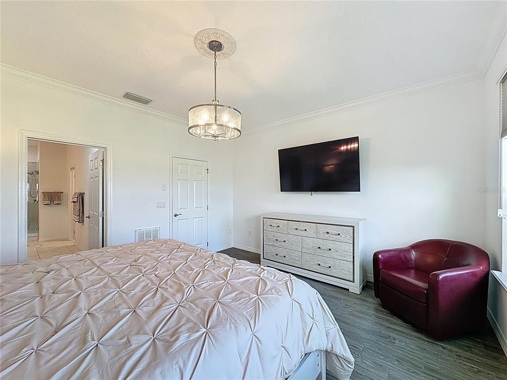 178 Silver Maple Road Groveland, FL 34736 - Photo 18 of 72 a bedroom with a bed and a flat screen tv