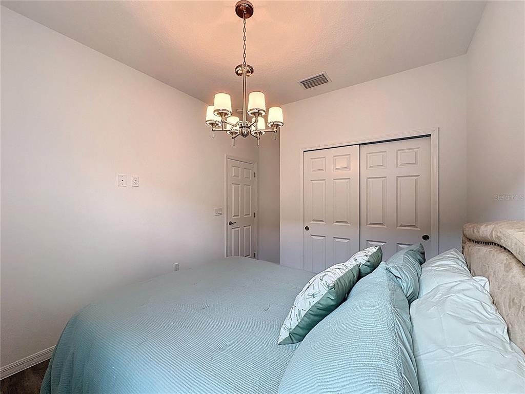 178 Silver Maple Road Groveland, FL 34736 - Photo 24 of 72 a bed room with a bed and a chandelier