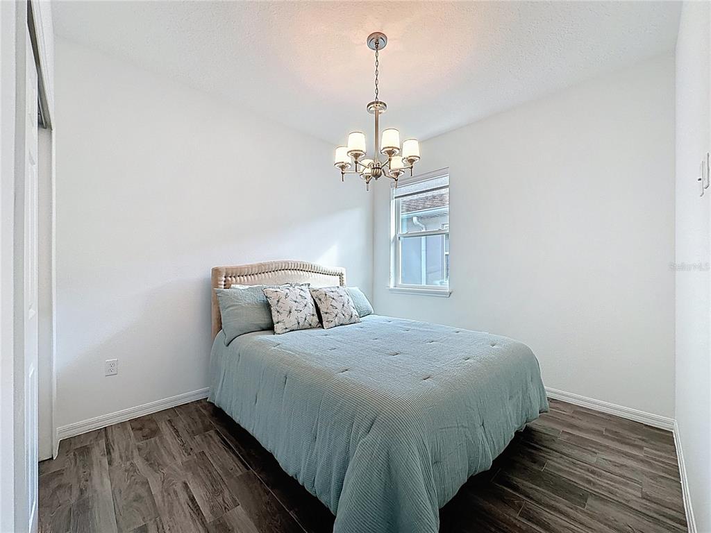 178 Silver Maple Road Groveland, FL 34736 - Photo 31 of 72 a bedroom with a bed and wooden floor