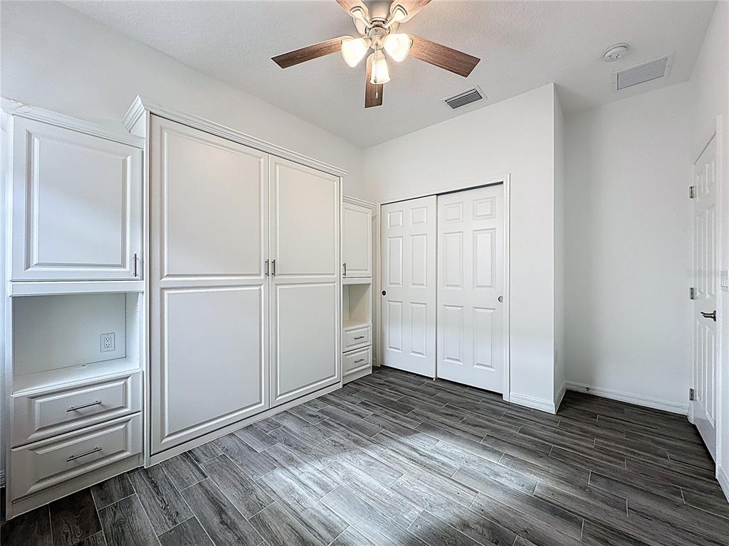 178 Silver Maple Road Groveland, FL 34736 - Photo 34 of 72 a view of empty room with wooden floor and kitchen view