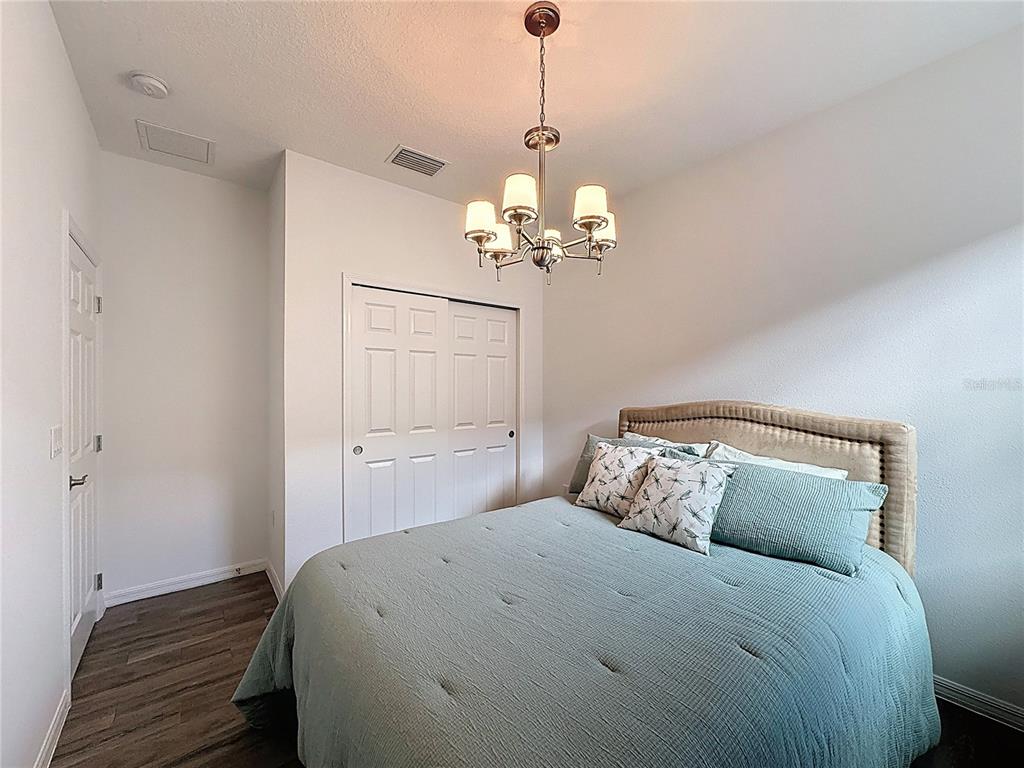 178 Silver Maple Road Groveland, FL 34736 - Photo 36 of 72 a bedroom with a bed and a chandelier