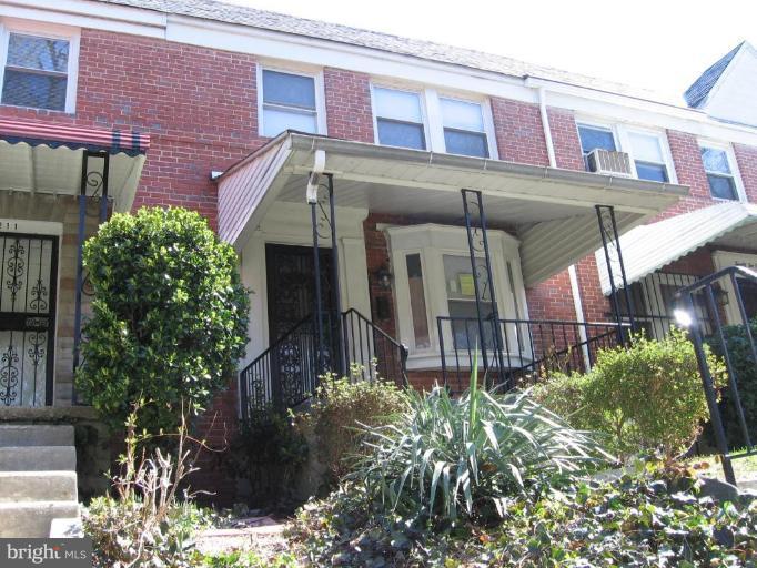 2209 Monticello Road Baltimore, MD 21216 - Photo 2 of 30 a view of a brick building with plants and a bench