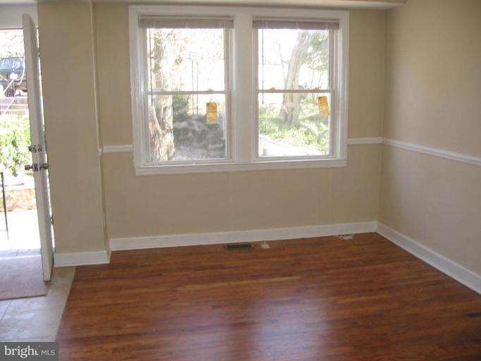 2209 Monticello Road Baltimore, MD 21216 - Photo 7 of 30 an empty room with wooden floor and windows