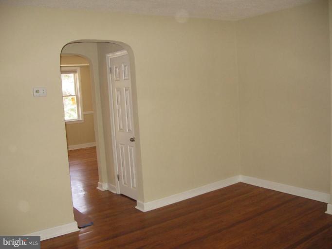 2209 Monticello Road Baltimore, MD 21216 - Photo 8 of 30 a view of a room with wooden floor and mirror