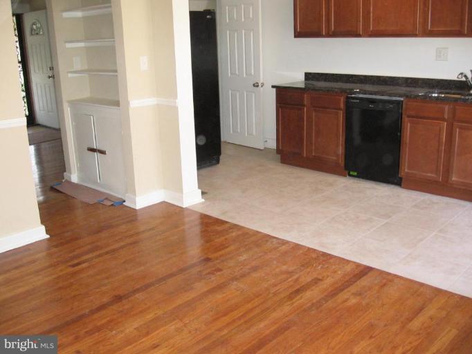 2209 Monticello Road Baltimore, MD 21216 - Photo 9 of 30 an empty room with wooden floor and cabinet