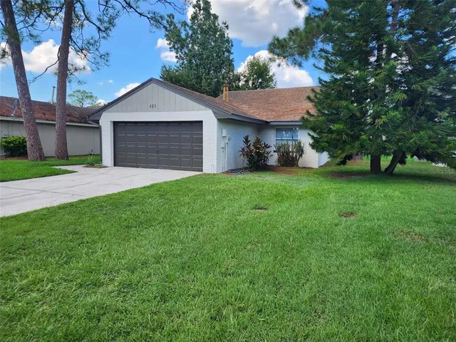 a front view of a house with a garden and trees