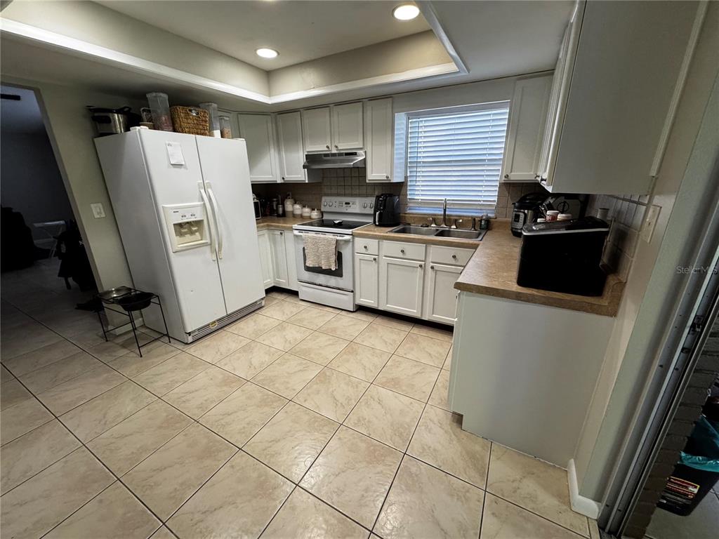 423 Greenfield Road Winter Haven, FL 33884 - Photo 2 of 14 a kitchen with a refrigerator a stove top oven and cabinets
