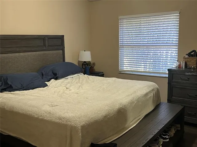 a bed sitting in a bedroom next to a window