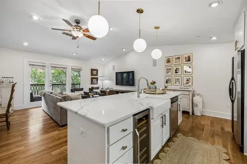 a large kitchen with stainless steel appliances a large center island attached withe living room