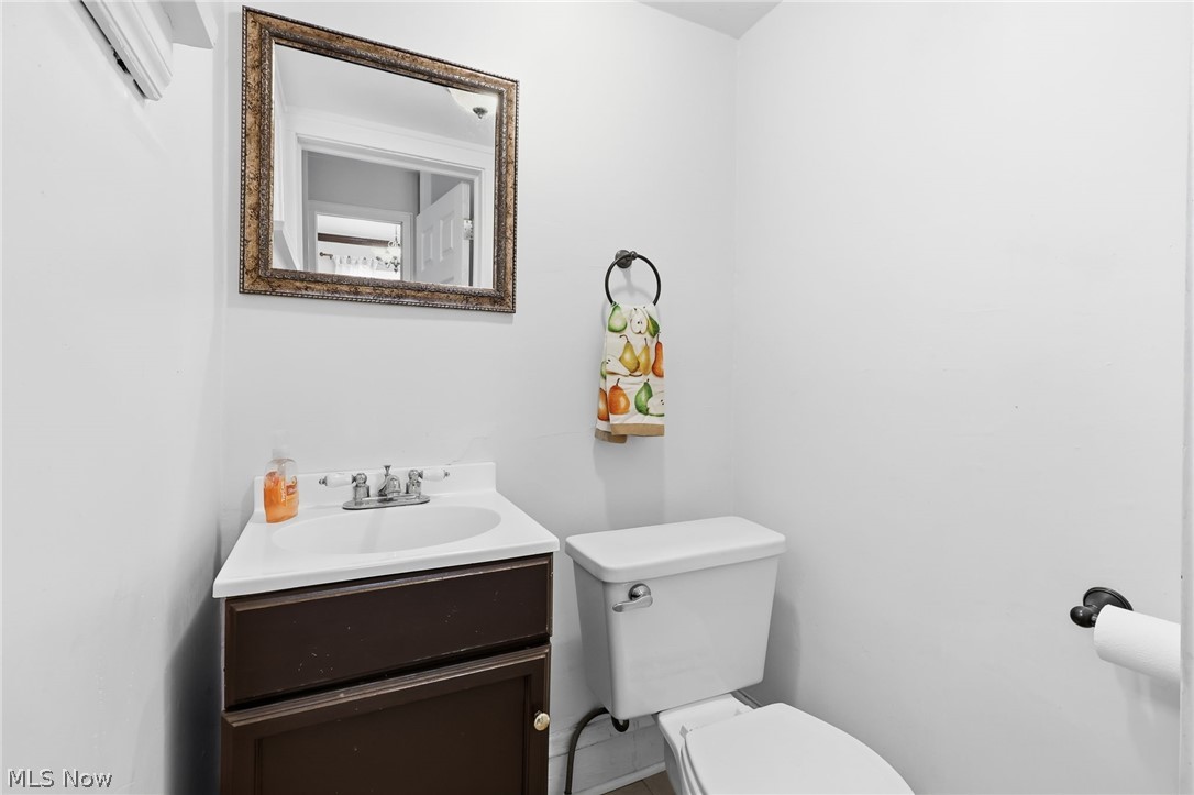 3511 Northcliffe Road Cleveland, OH 44118 - Photo 16 of 46 Powder room featuring a white single-basin vanity with a dark wood-finish cabinet, a decorative framed mirror, and a white toilet