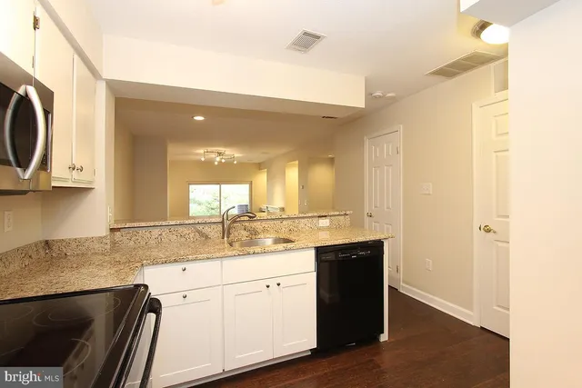 a kitchen with a sink cabinets and a wooden floor