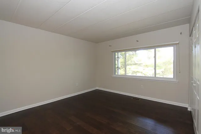 a view of a room that has wooden floor and large window
