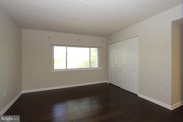 a view of a room with wooden floor and windows