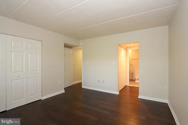 an empty room with wooden floor and closet