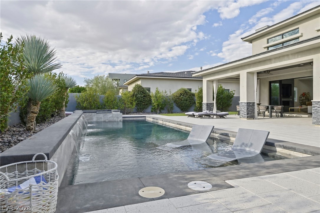 4208 Lapis Ridge Court Las Vegas, NV 89135 - Photo 42 of 61 A spacious stone patio frames the sleek swimming pool featuring an integrated waterfall wall.