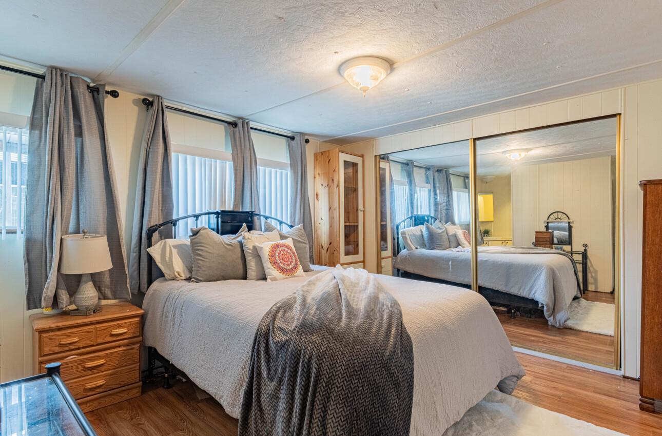 55 San Juan Grade Road, Unit 79 Salinas, CA 93906 - Photo 11 of 22 a bedroom with bed and a large mirror with wooden floor