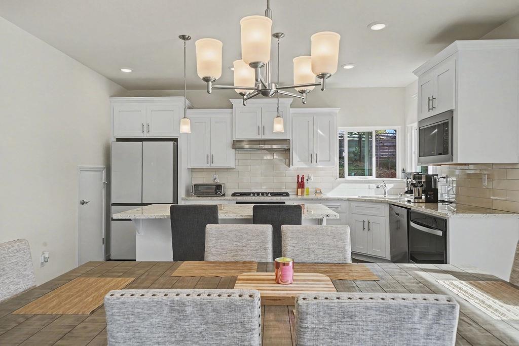 13871 Petersen Ranch Drive Pine Grove, CA 95665 - Photo 11 of 74 a kitchen with kitchen island stainless steel appliances a stove refrigerator sink and fireplace