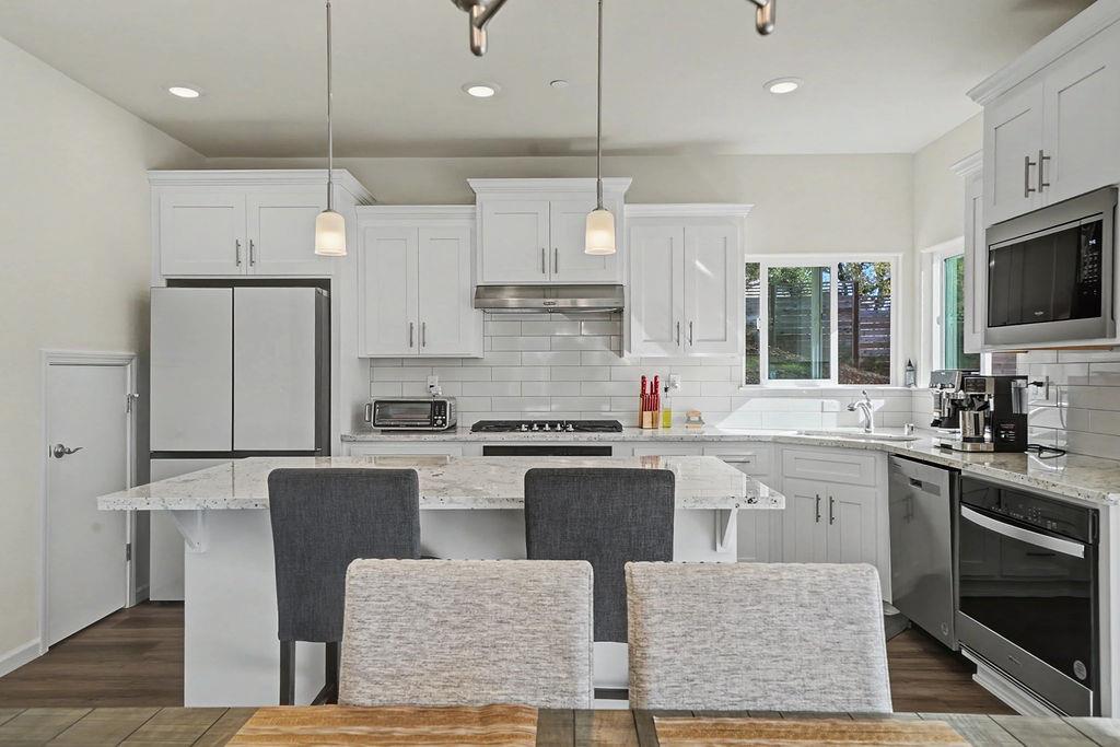 13871 Petersen Ranch Drive Pine Grove, CA 95665 - Photo 12 of 74 a kitchen with stainless steel appliances granite countertop a stove top oven a sink dishwasher a dining table and chairs