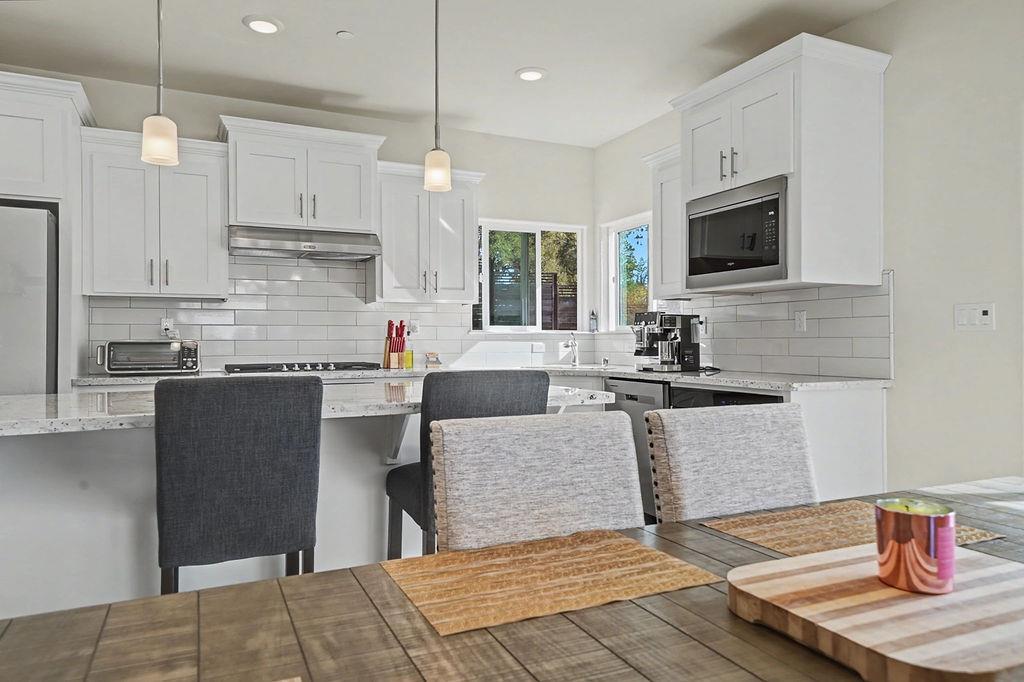 13871 Petersen Ranch Drive Pine Grove, CA 95665 - Photo 14 of 74 a kitchen with stainless steel appliances granite countertop a refrigerator a sink dishwasher a stove and white cabinets with wooden floor