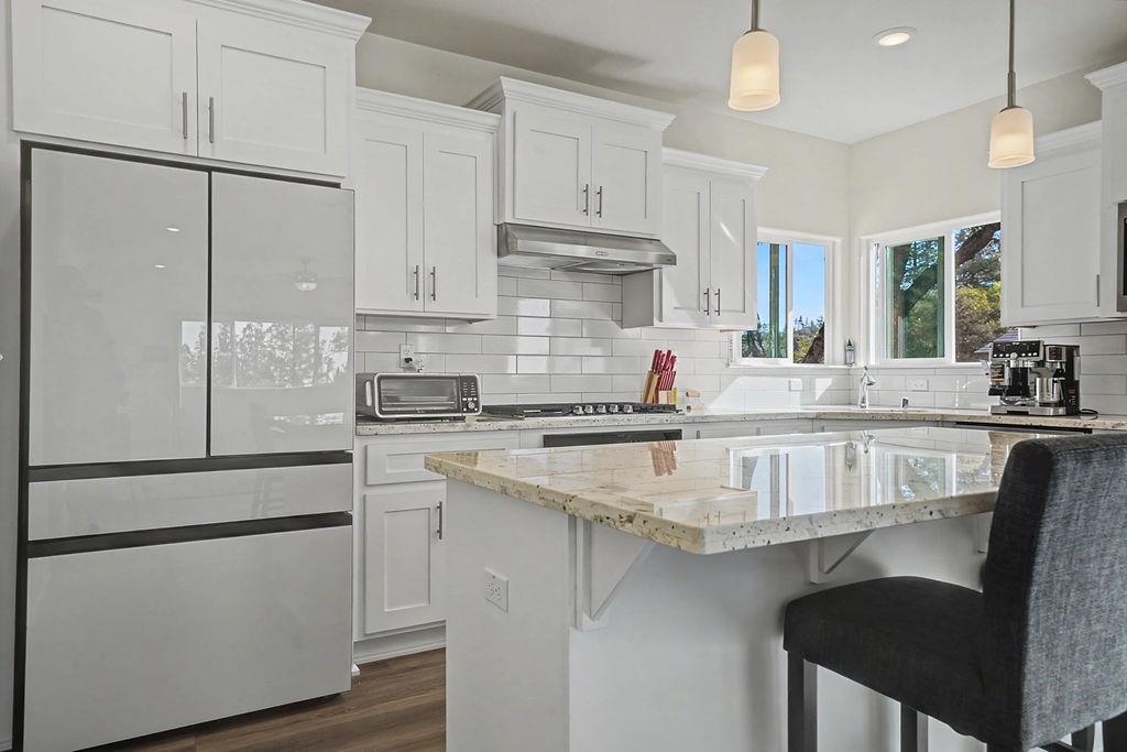 13871 Petersen Ranch Drive Pine Grove, CA 95665 - Photo 15 of 74 a kitchen with kitchen island white cabinets and refrigerator