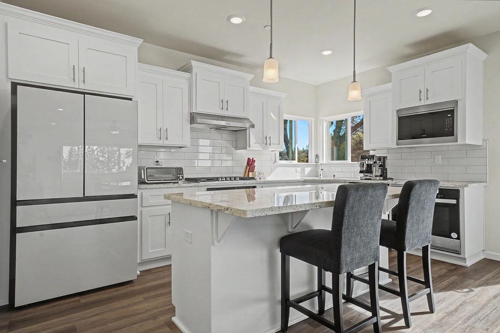 13871 Petersen Ranch Drive Pine Grove, CA 95665 - Photo 16 of 74 a kitchen with stainless steel appliances white cabinets and a table