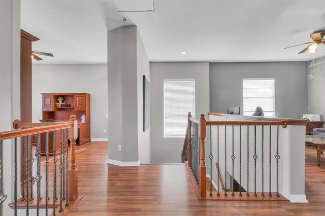 a view of a hallway with wooden floor and windows