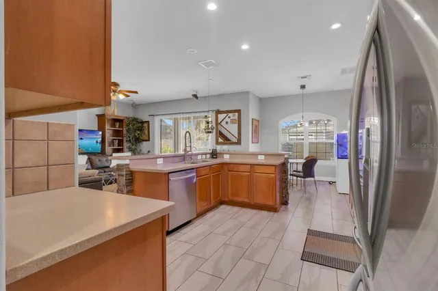 a kitchen with stainless steel appliances granite countertop a sink counter space and chairs