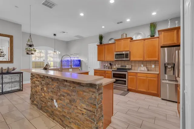 a kitchen with stainless steel appliances granite countertop a stove refrigerator and a sink