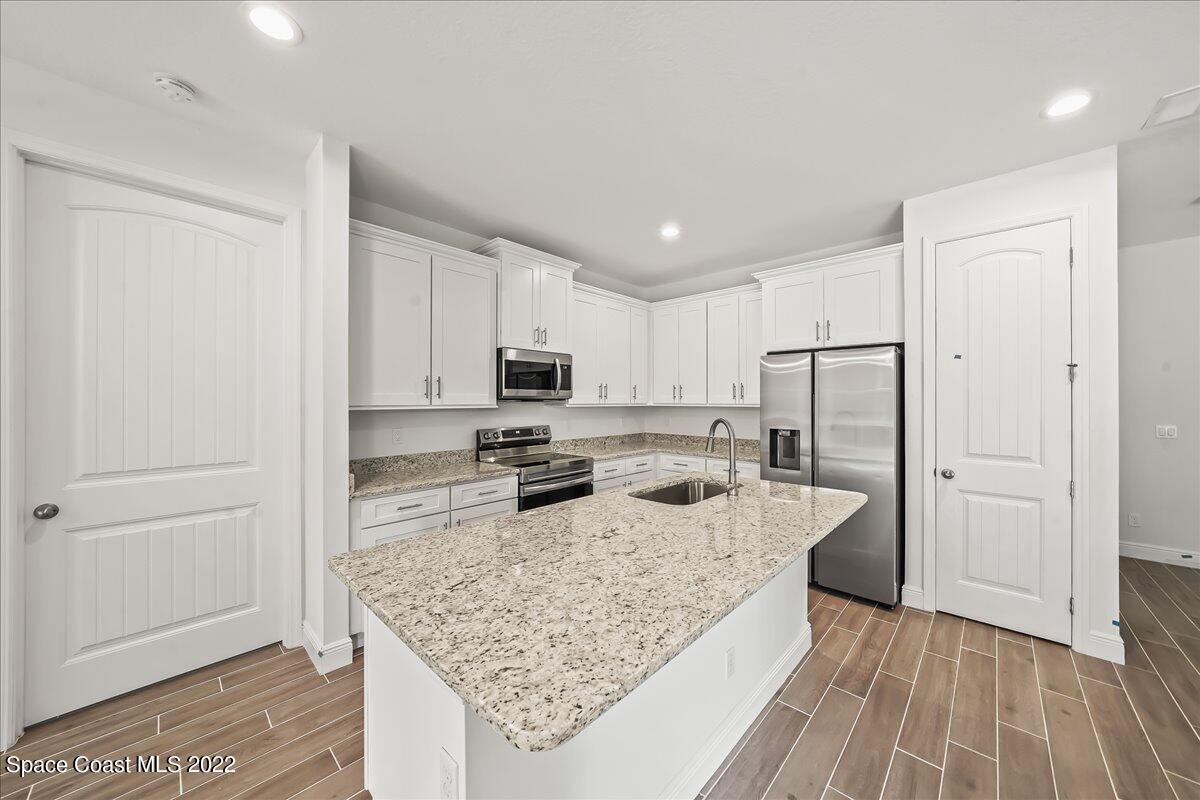 1296 Daton Road Southwest Palm Bay, FL 32908 - Photo 3 of 32 a kitchen with stainless steel appliances granite countertop a sink stove and refrigerator