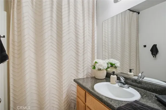 a bathroom with a granite countertop sink and a mirror