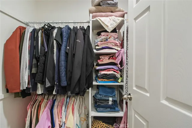 a view of walk in closet with clothes and shoes