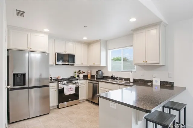 a kitchen with cabinets appliances a sink and a counter top space